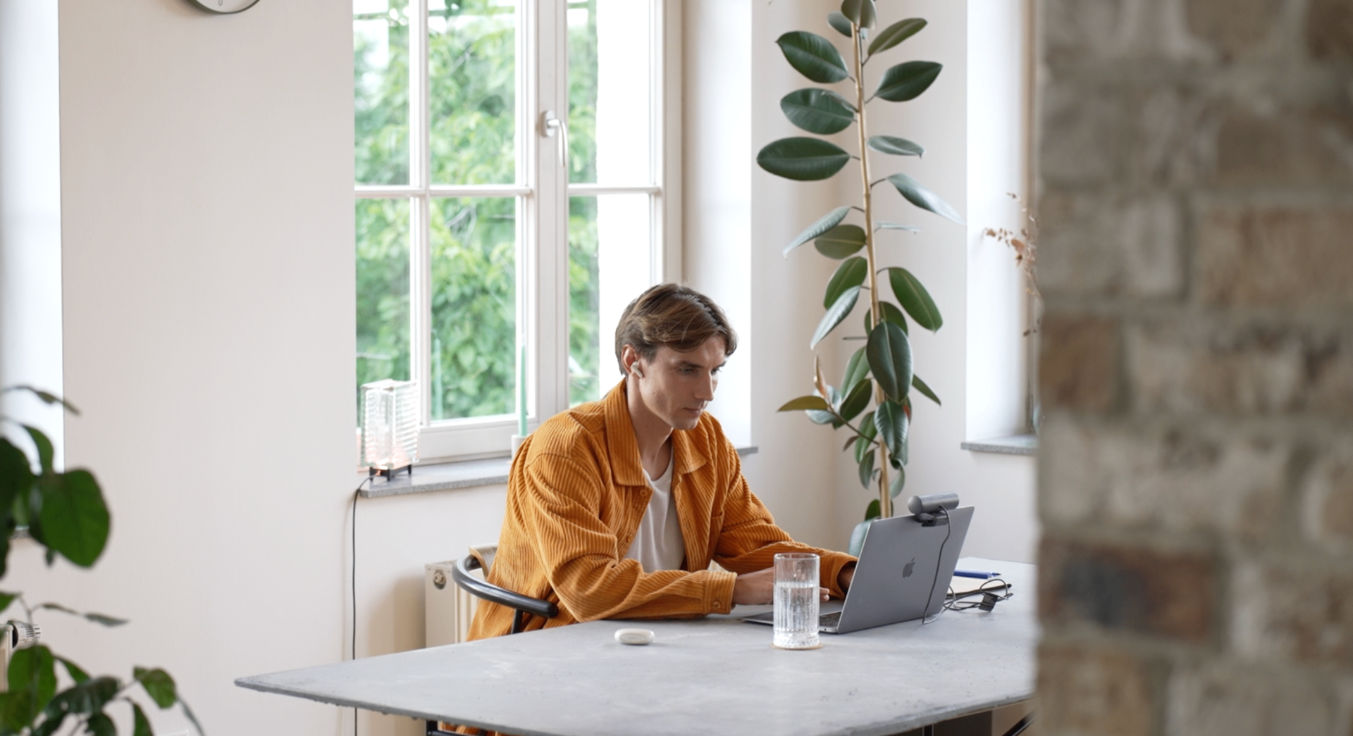 Julian arbeitet konzentriert am Laptop an einem hellen Arbeitsplatz